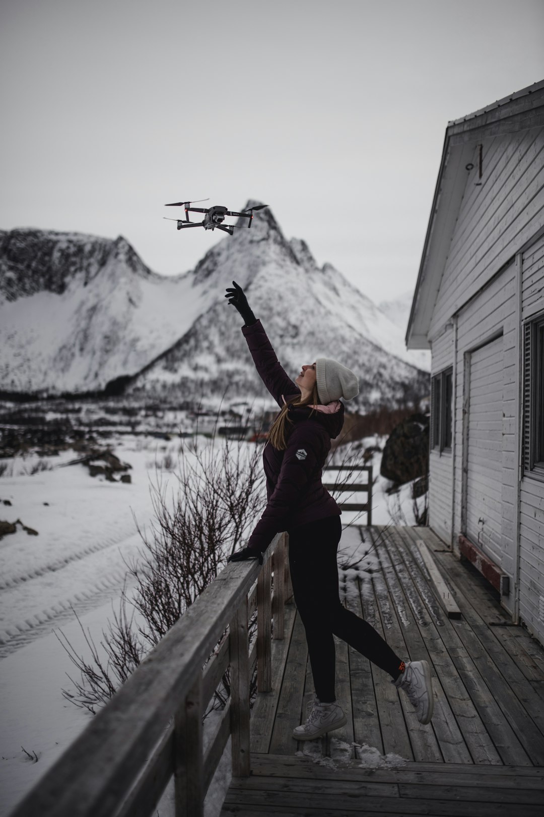 woman in black jacket and black pants holding orange and black snow blower