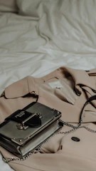 Classic trench coat with a belt detail, draped over a city park bench.