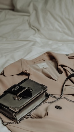 A modern trench coat draped over a sleek chair in a bright, minimalist studio setting.