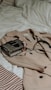 brown leather sling bag on white and red textile