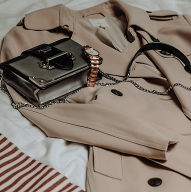 brown leather sling bag on white and red textile