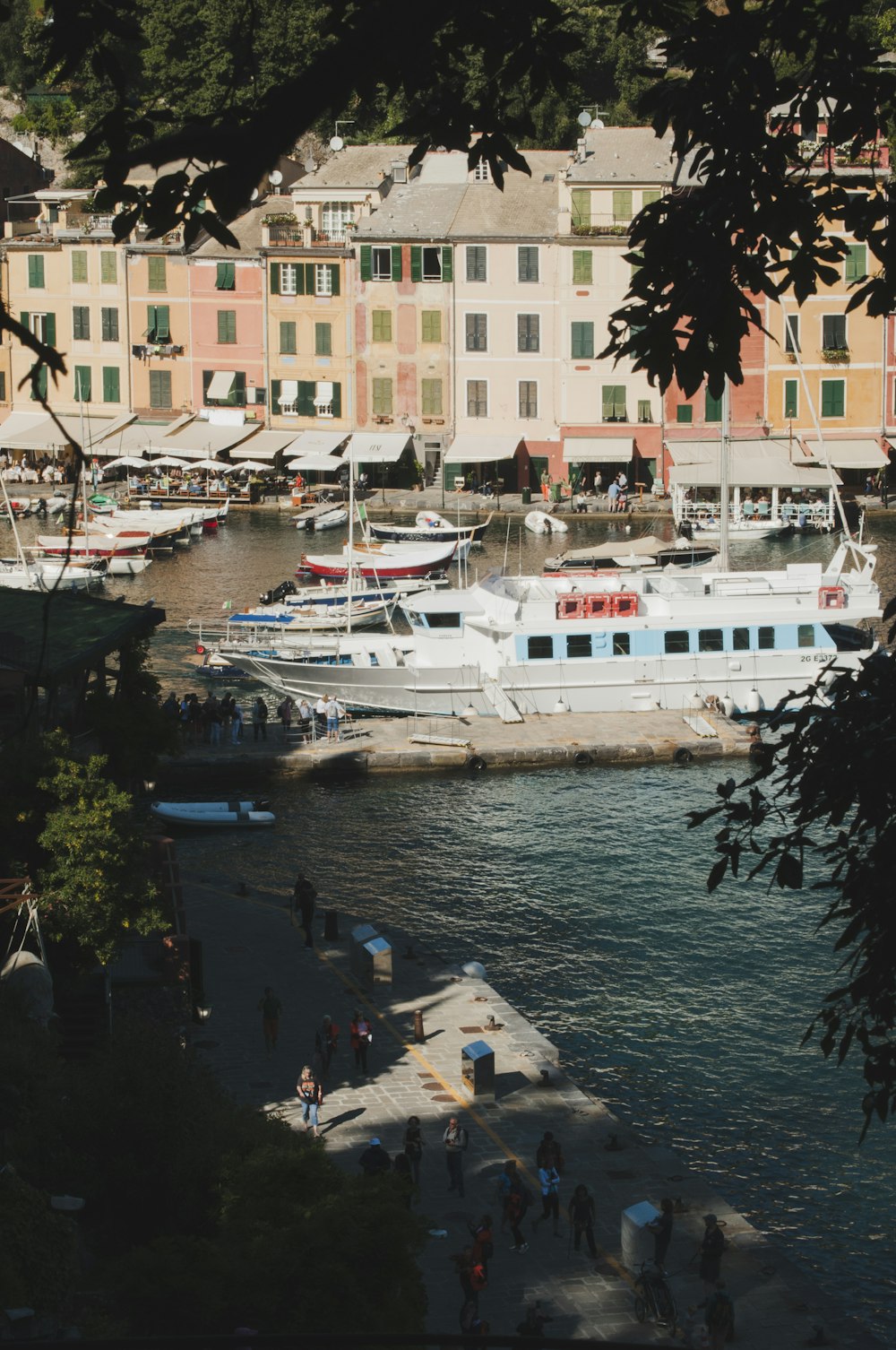 white and blue boat on water near brown concrete building during daytime