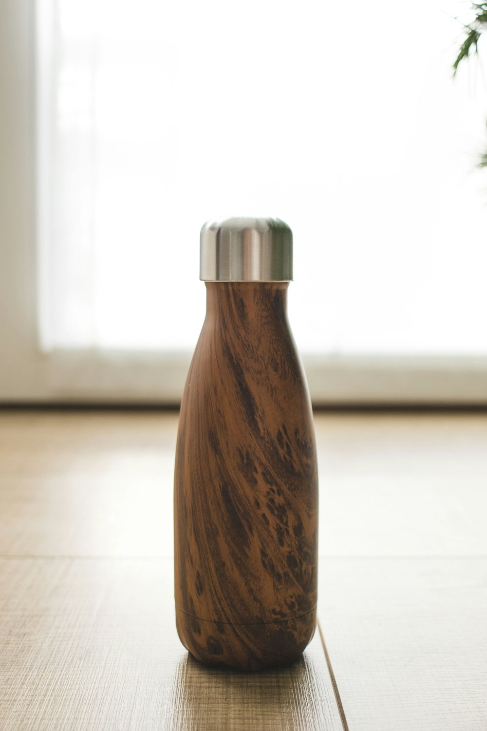 Botella de madera marrón sobre mesa blanca