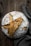 Close-up of a golden-brown sourdough loaf resting on a rustic wooden board with flour dusted around.