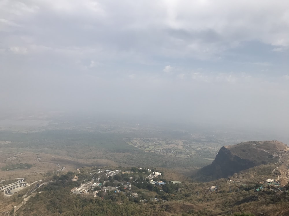 aerial view of green mountains under cloudy sky during daytime