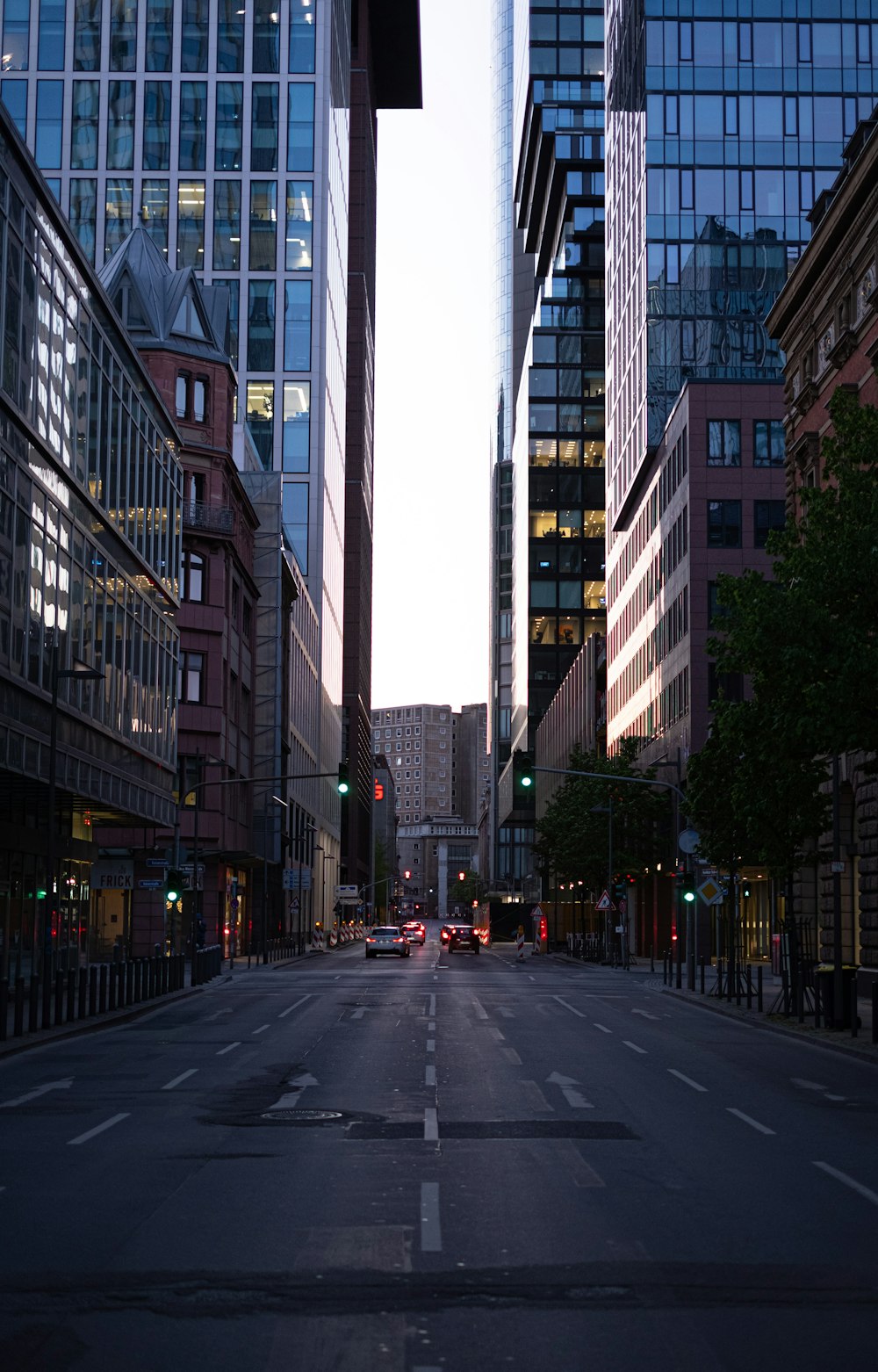 black car on road in between high rise buildings during daytime