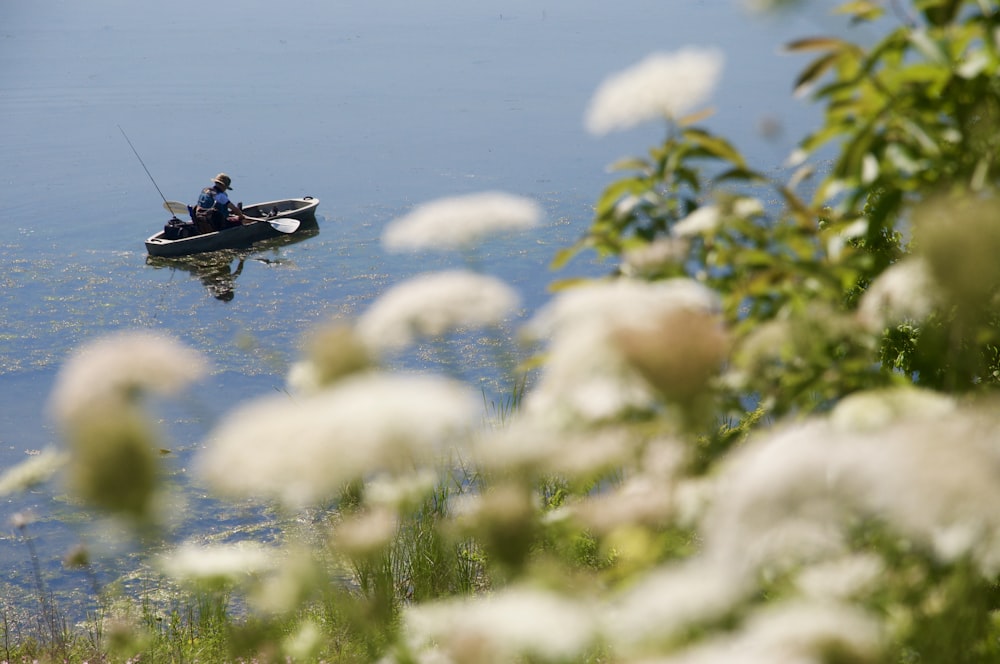 man riding on black and red boat on body of water during daytime