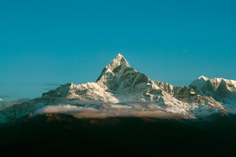 montanha coberta de neve sob o céu azul durante o dia