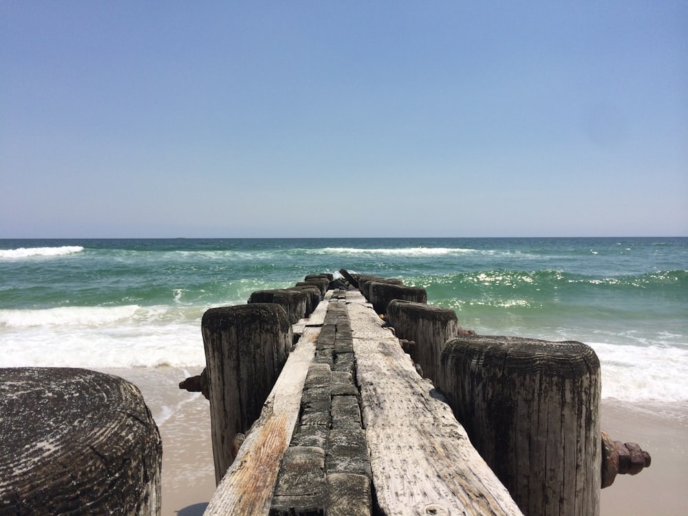 brown wooden dock on blue sea under blue sky during daytime