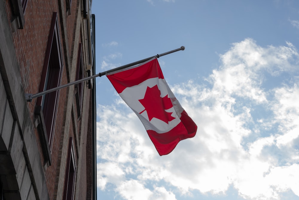 red and white flag on pole under cloudy sky during daytime