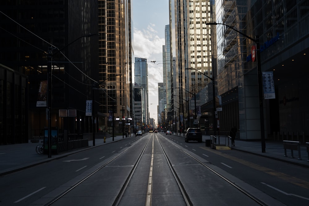 gray concrete road between high rise buildings during daytime