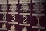Several volumes of books with dark brown covers and gold embossed titles in Ukrainian, arranged in a row. Each book has a volume number prominently displayed, and there are decorative designs and images of leaves on the covers.