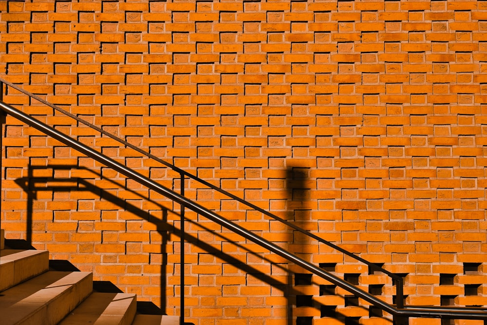 black metal staircase on brown brick wall