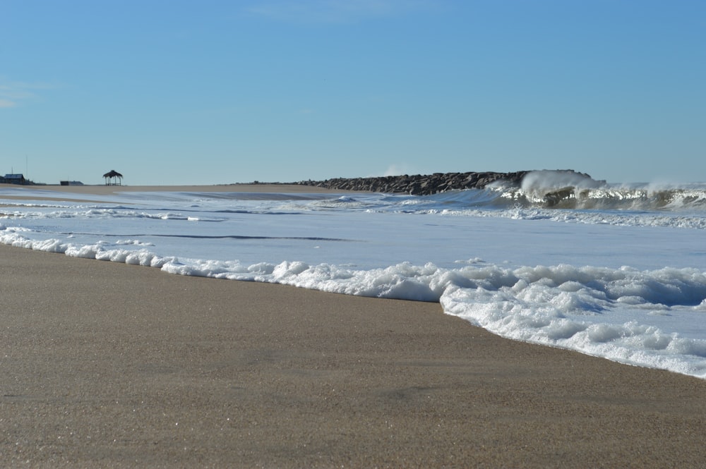 ocean waves crashing on shore during daytime