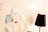 A variety of sticky notes with handwritten text are attached to a white wall, displaying what seems to be study materials or reminders. A black desk lamp is positioned nearby, casting light on the notes.