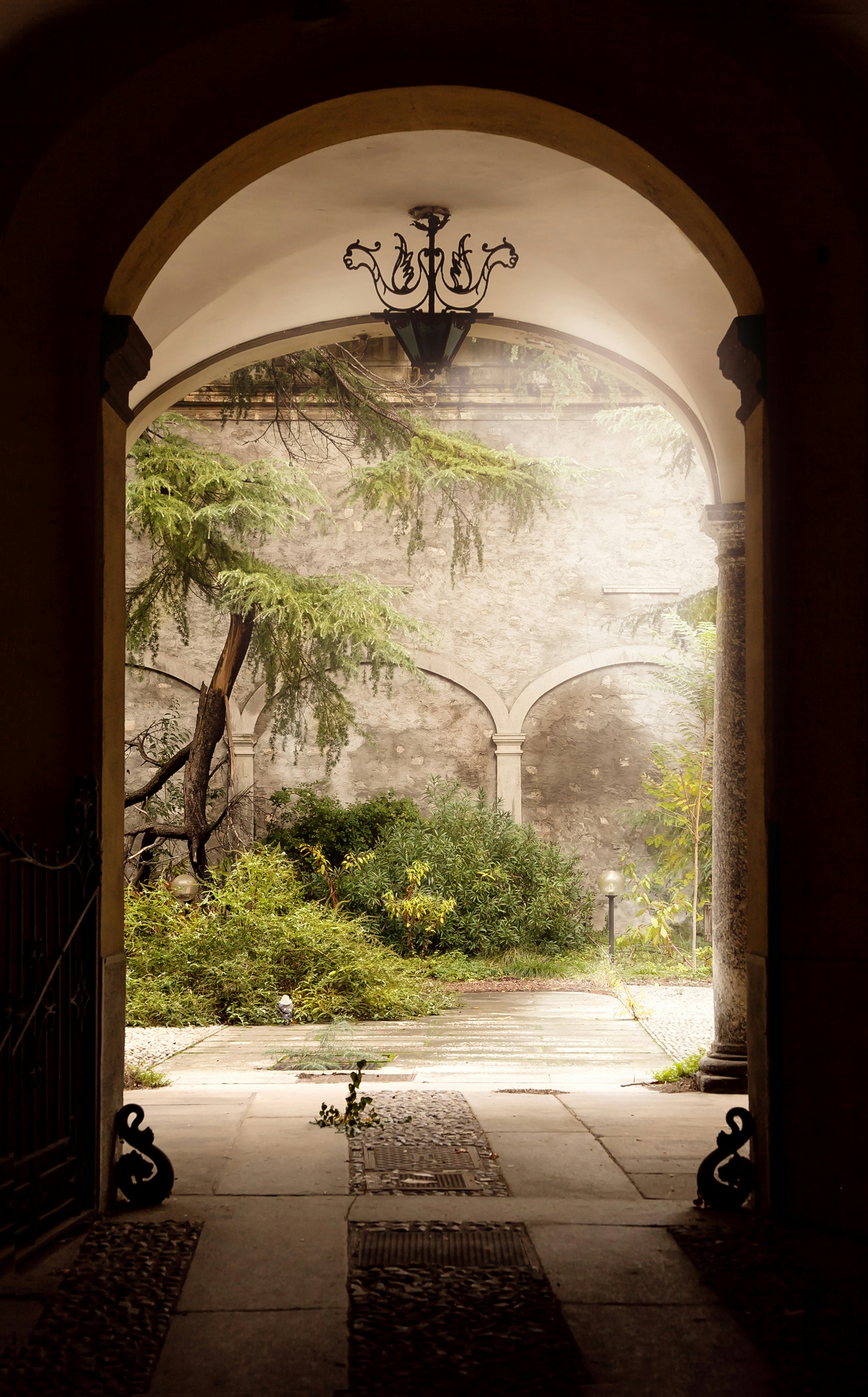 Puerta de arco de madera marrón cerca de árboles verdes durante el día