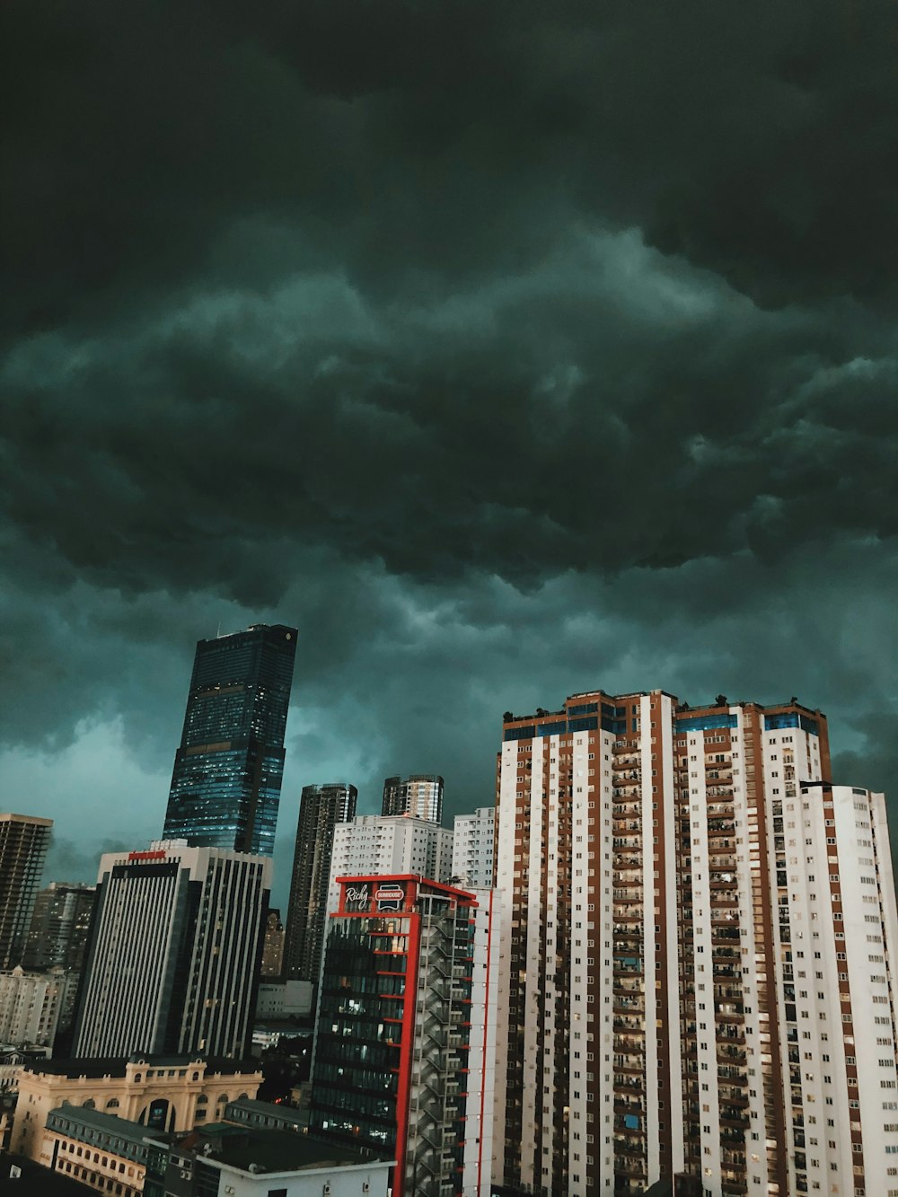 high rise buildings under gray clouds