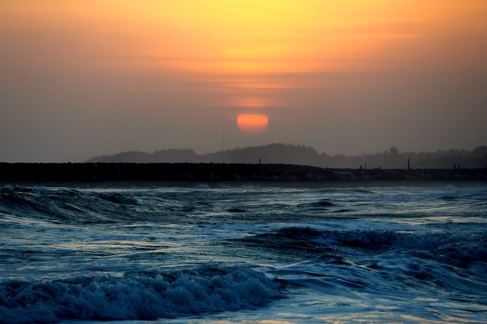 ocean waves crashing on shore during night time