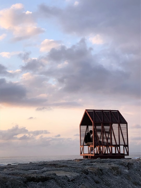 brown wooden house on sea shore under cloudy sky during daytime in Esmoriz Portugal