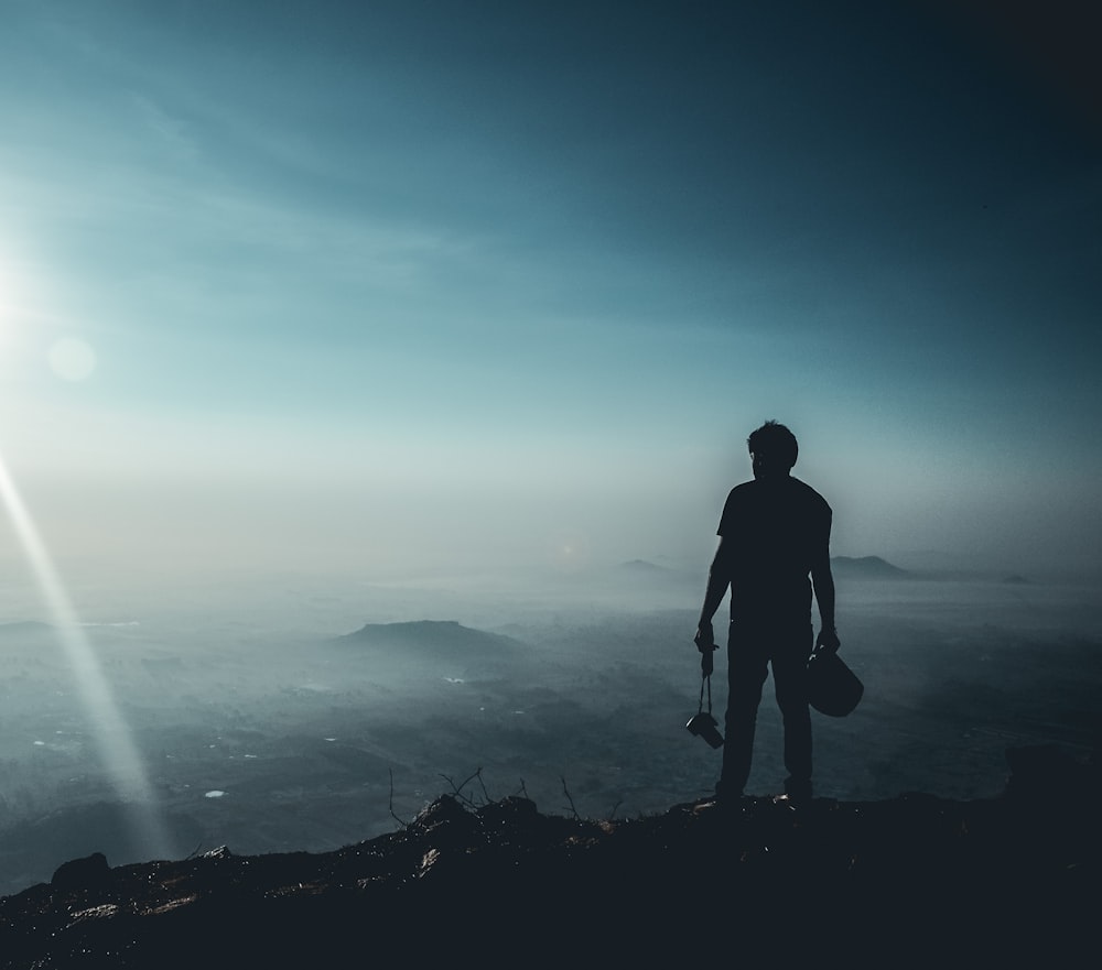 a man standing on top of a mountain with a guitar