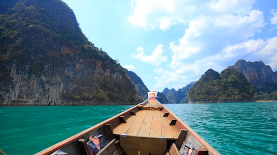 brown wooden boat on blue sea during daytime in Krabi Thailand