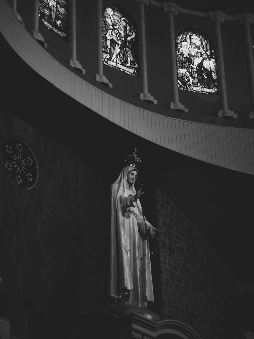 grayscale photo of woman in dress statue
