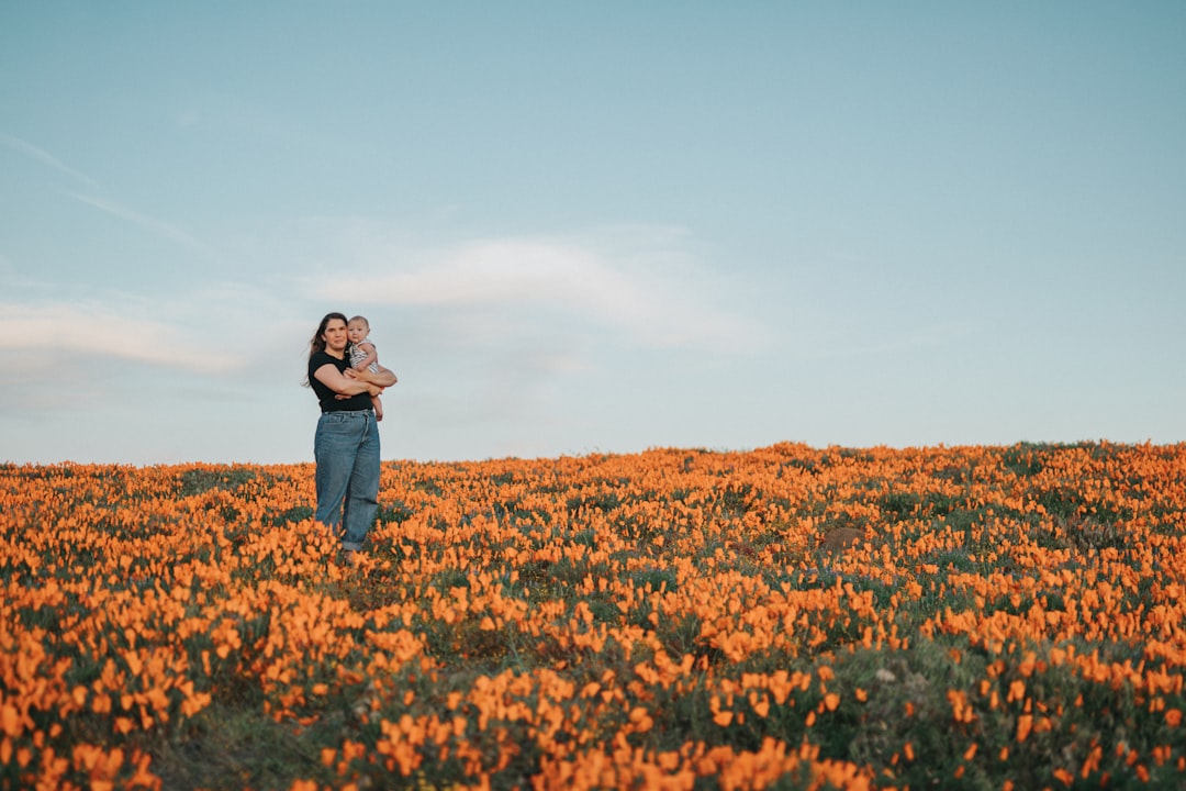 woman in black jacket standing on brown grass field during daytime