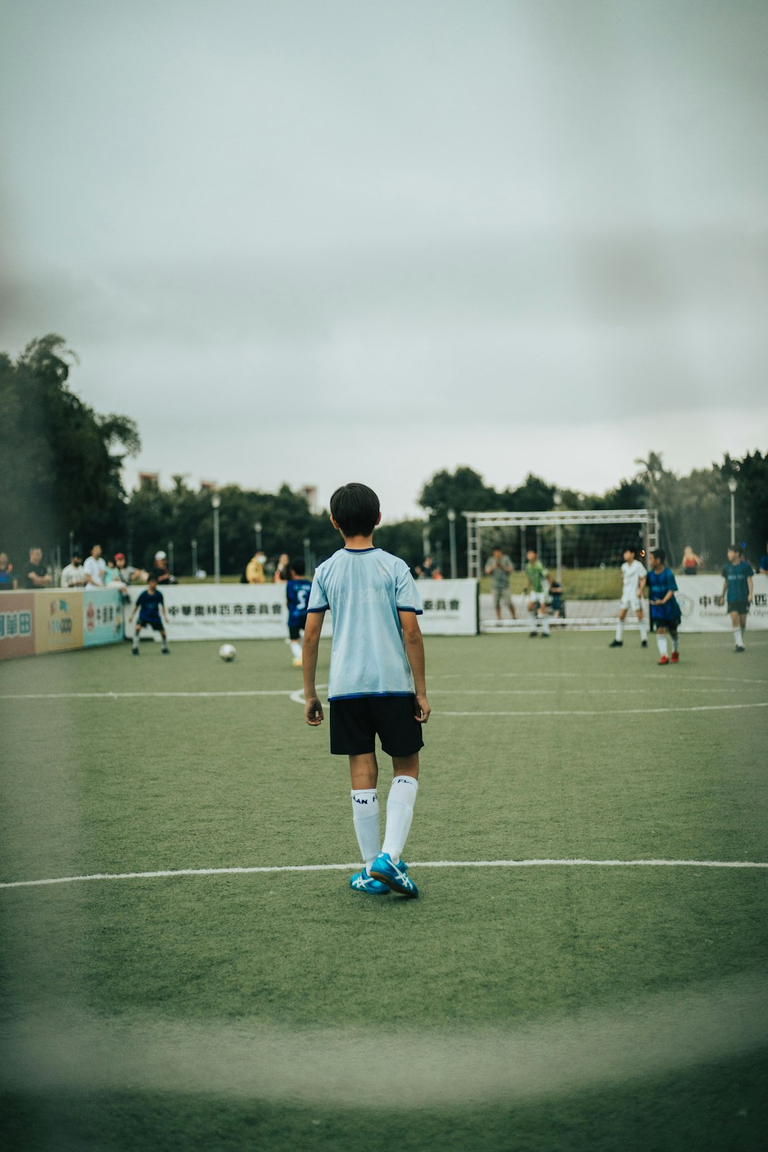 man in white and blue soccer jersey standing on green field during daytime