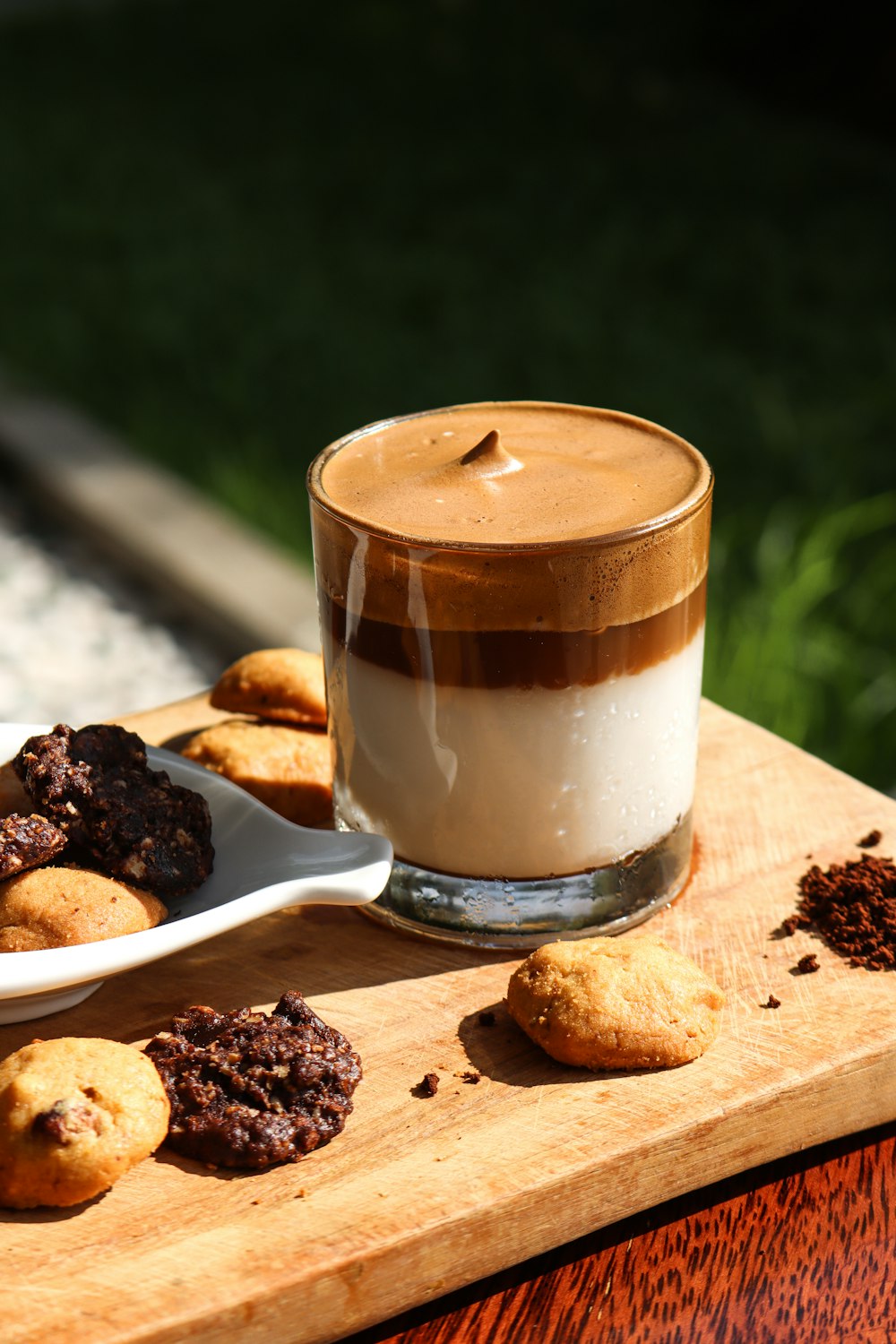 white ceramic mug with coffee on brown wooden chopping board