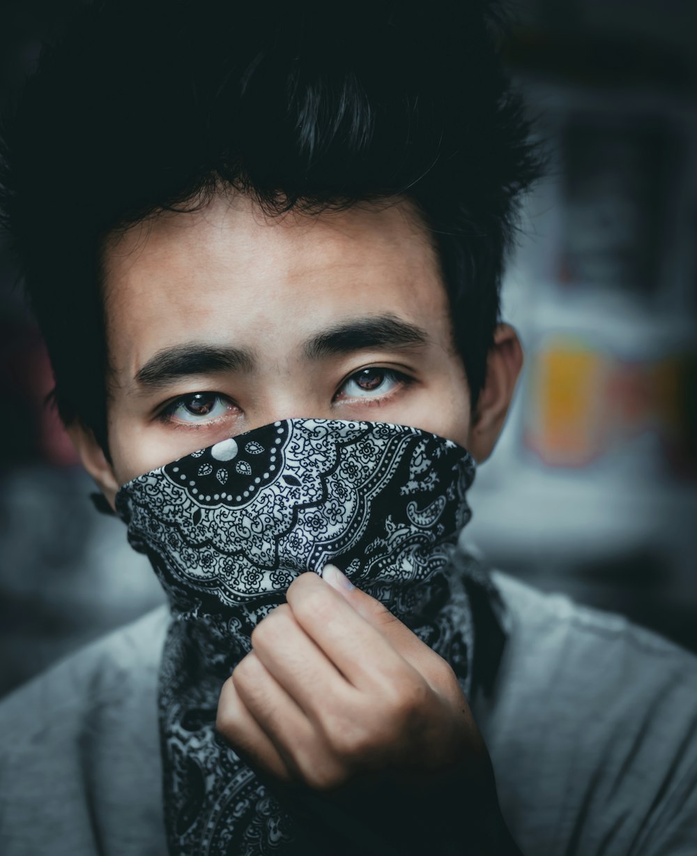 woman in black and white scarf covering face with black and white floral scarf