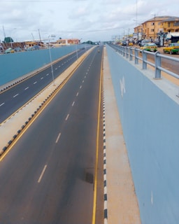 gray concrete road near body of water during daytime