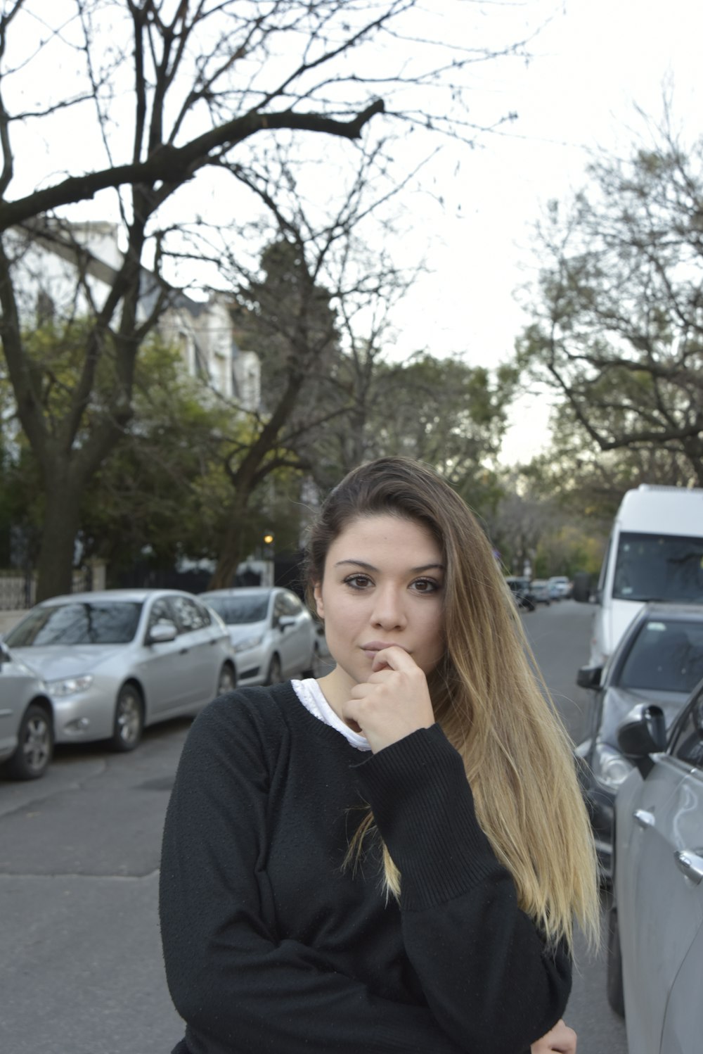 woman in black blazer standing near cars during daytime