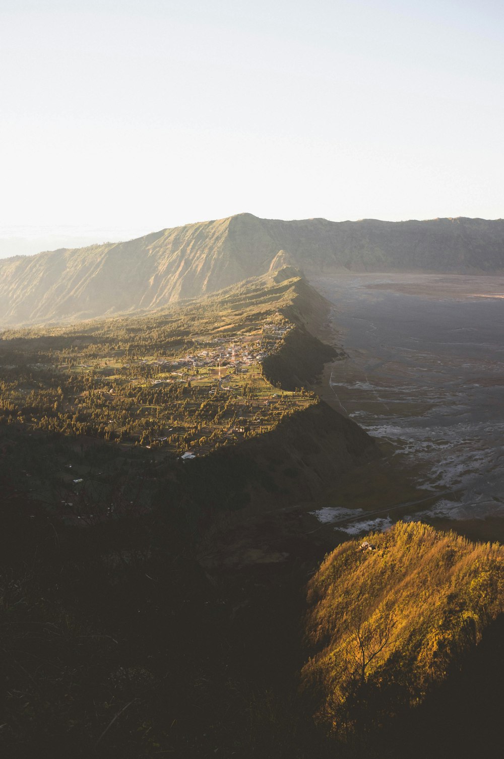 green and brown mountain beside body of water during daytime