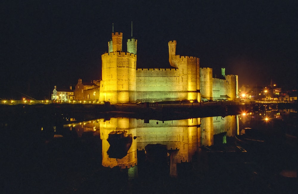 brown concrete castle on water during night time