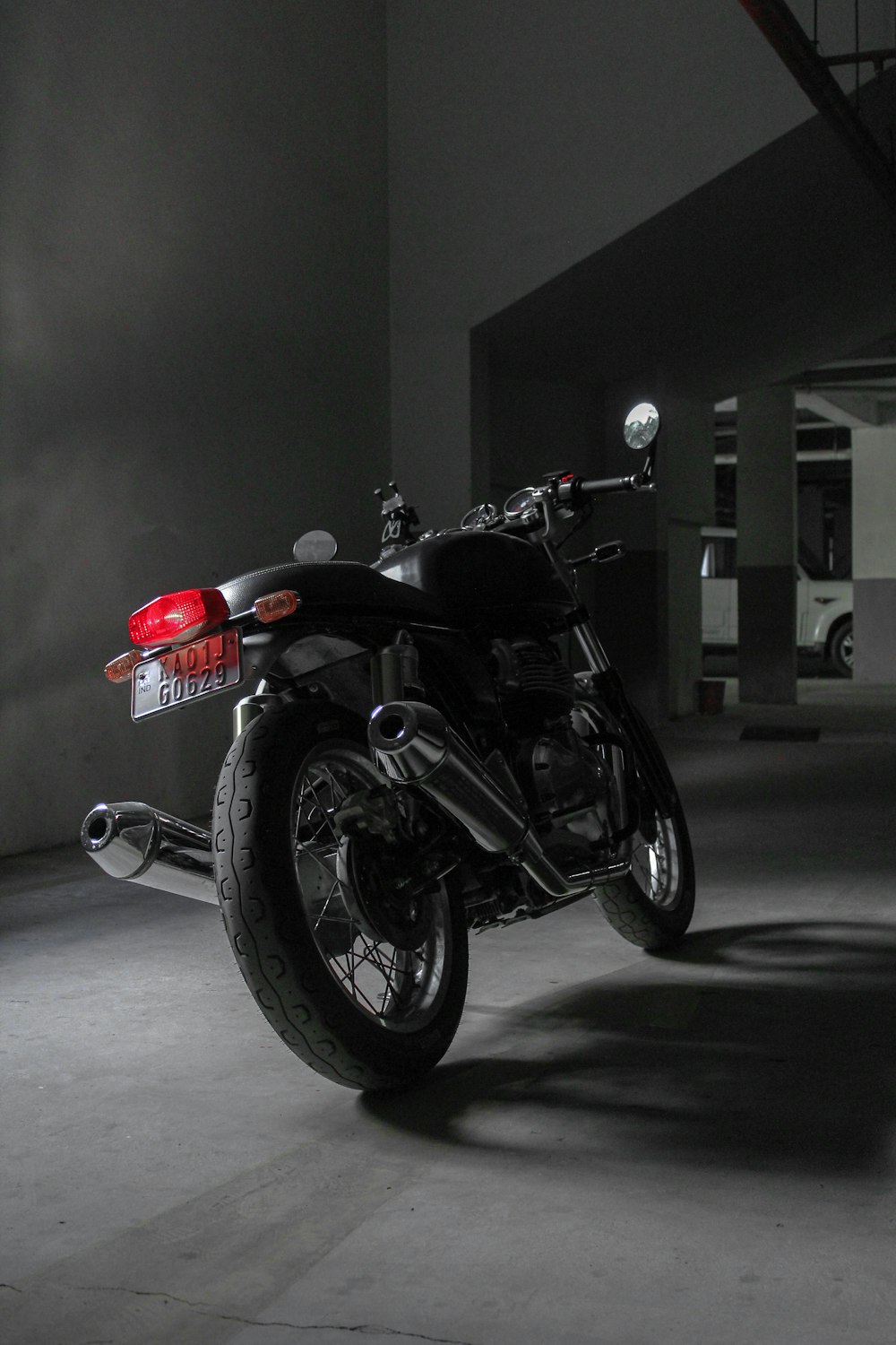 black and red motorcycle parked on gray pavement