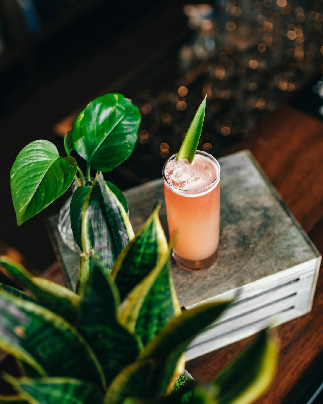 clear drinking glass with pink liquid on brown wooden table