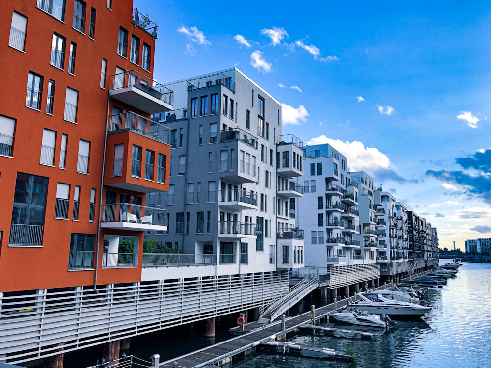 white and brown concrete buildings beside river under blue sky during daytime