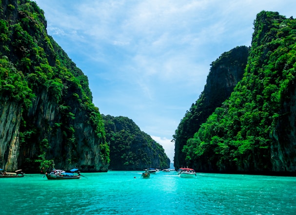 boats on sea near mountain during daytime