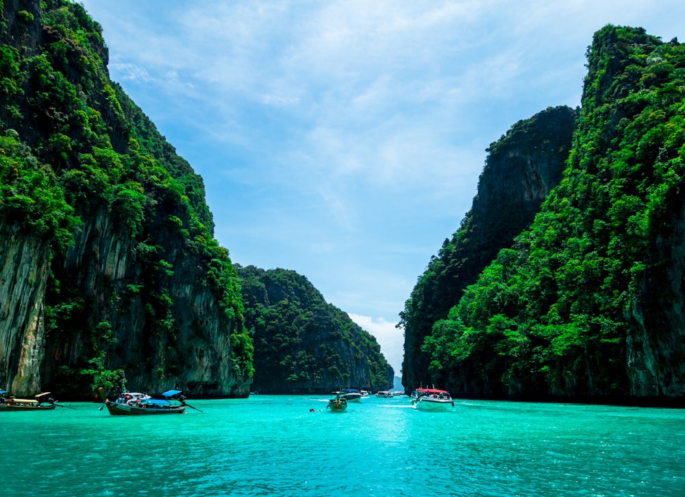 boats on sea near mountain during daytime