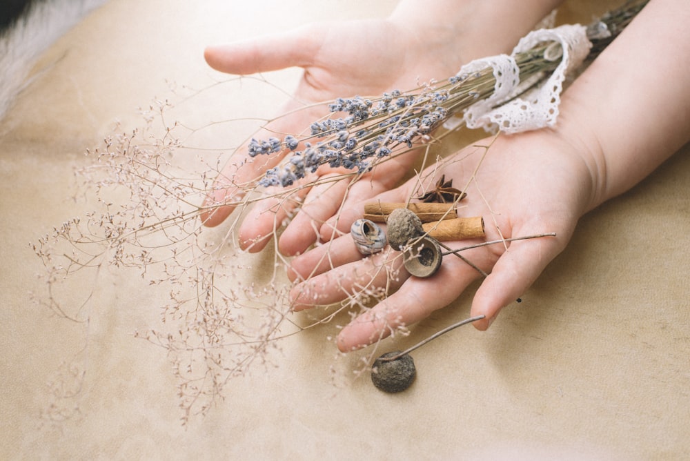 silver and gold necklace on persons hand