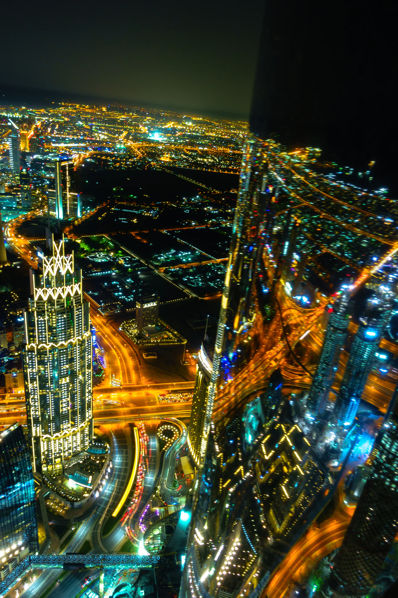 Dubai's lit-up streets and towers at night, seen from the top of Burj Khalifa
