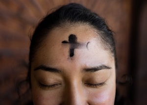 woman with black cross tattoo on her face