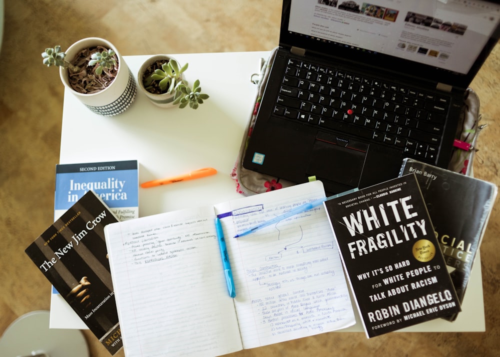 black laptop computer beside white printer paper