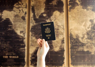 A smiling traveler holding a plane ticket with a world map in the background.
