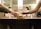 Two individuals are in a restroom, with one person handing a sanitary pad to the other. They are standing near a sink with mirrors and a hand sanitizer dispenser is visible in the background.