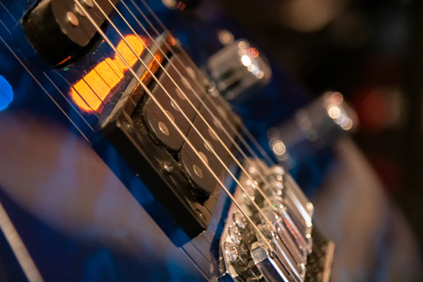 Close-up of a guitar tech carefully adjusting strings on a vintage electric guitar under soft studio lighting.