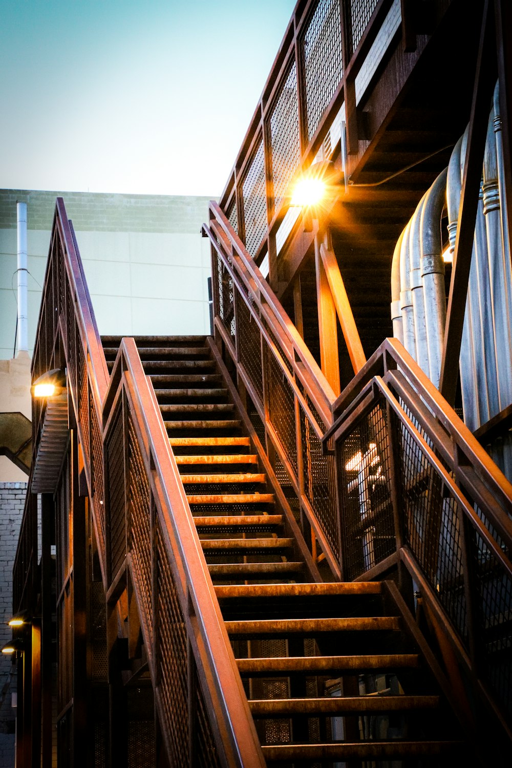 brown wooden staircase with white wall