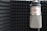 A professional recording studio with a microphone and soundproofing panels.