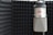 A professional recording studio with a microphone and soundproofing panels.
