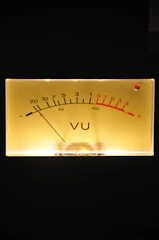 Close-up of a sleek, modern volt meter glowing softly in a dim room.